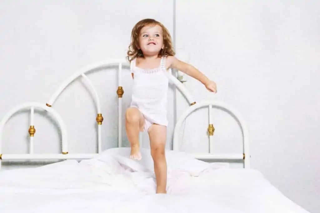 If your toddler is climbing out of the crib or you think they're ready to move to a big kid bed, it's best to read these words of caution and expert tips before you move them to a big bed. Making the transition to a big kid bed as easy as possible for everyone. Tips to transition to a big kid bed. Things to know before you move to a big kid bed. #bigkidbed #movetoabigkidbed #transitiontoabigkidbed #movingoutoftheircrib