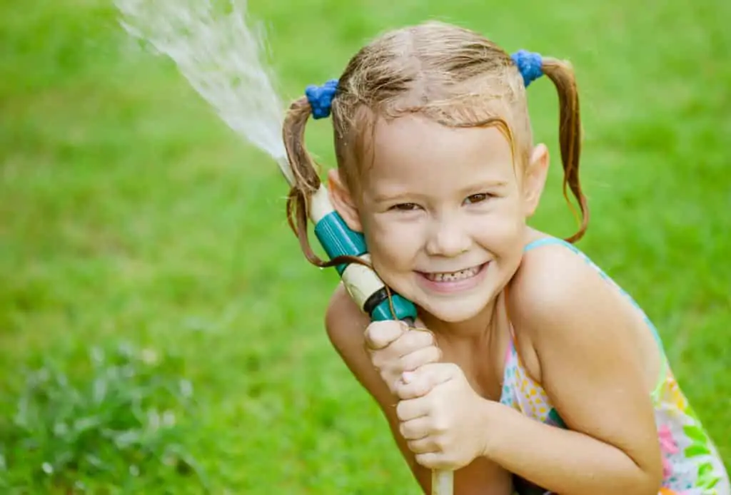 Ultimate Summer Bucket List and little girl playing in the water