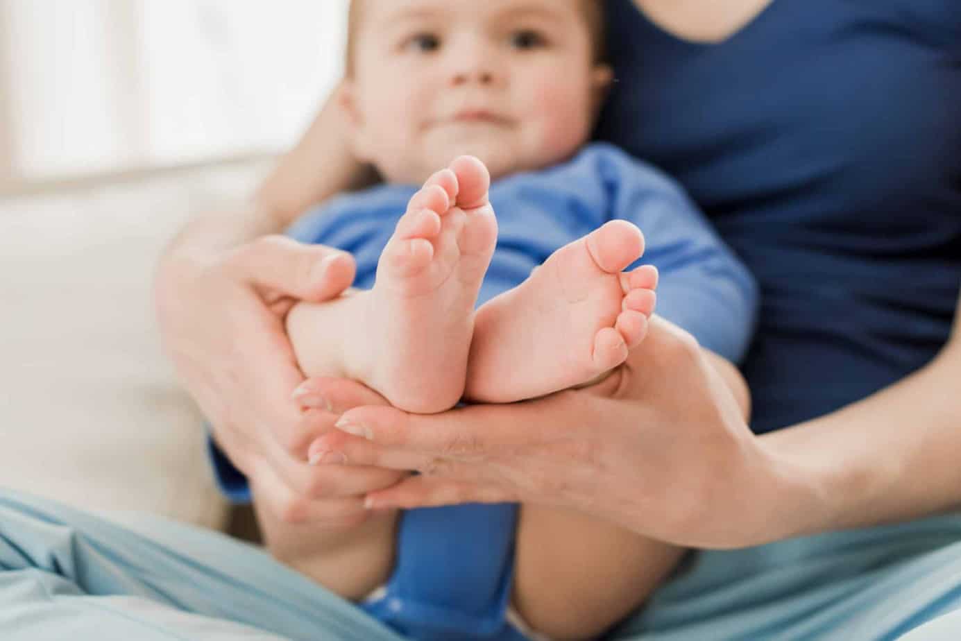 Mothers feet. Мама держит на коленях сына. Ножки ребенка на коленке у мамы. Ребенок держит маму за ногу. Ножки малыша 3 месяцев на коленях фото.